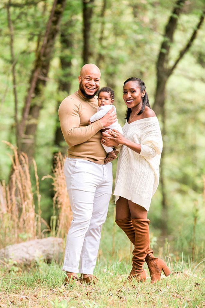 Black family outdoors with newborn wearing neutral colors