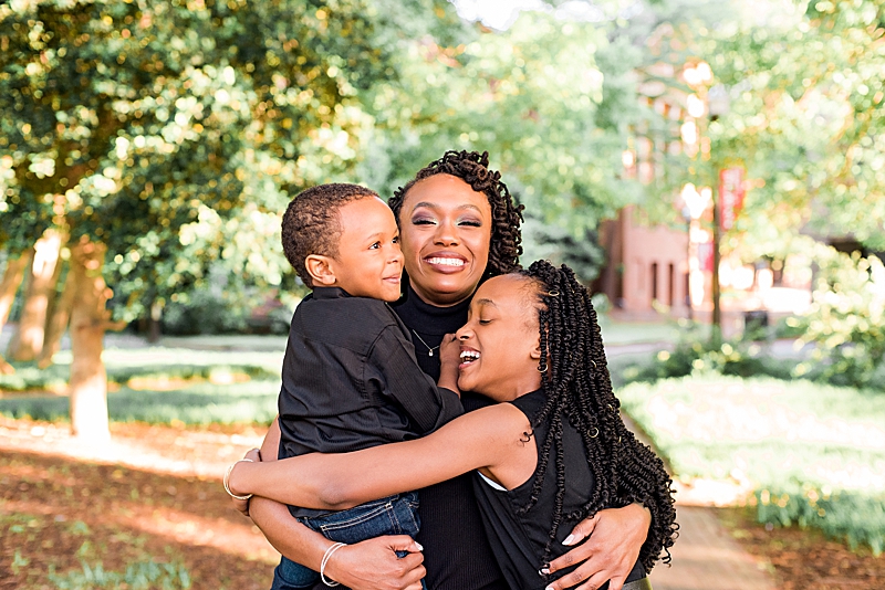 Black mother embracing her children outside. Single mother