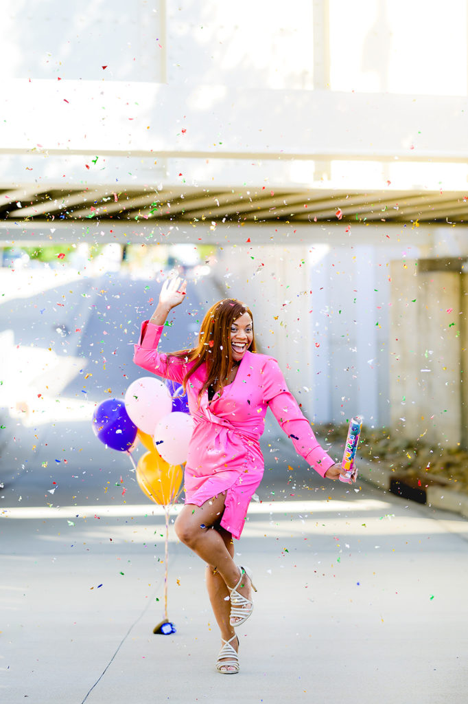 Celebration brand image of Black woman in pink dress with balloons