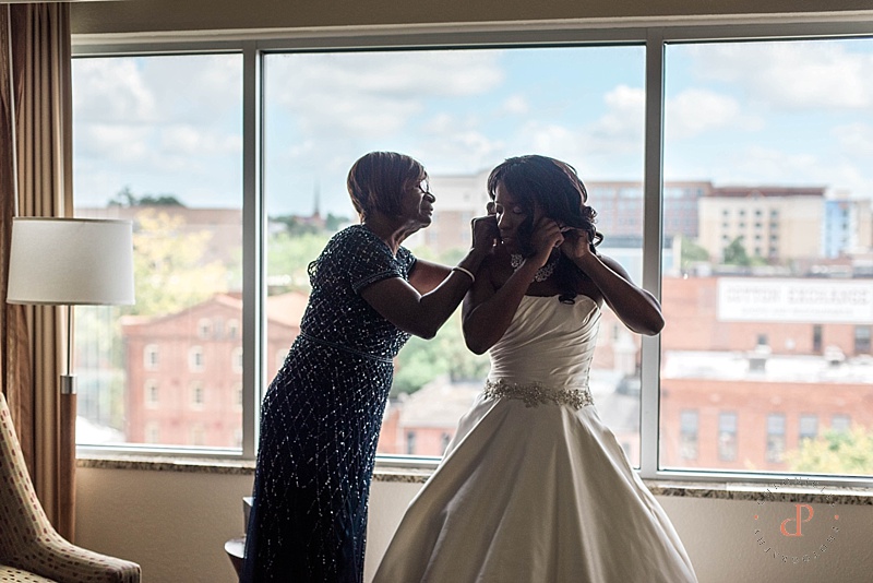 Mother helping bride get ready on her wedding day