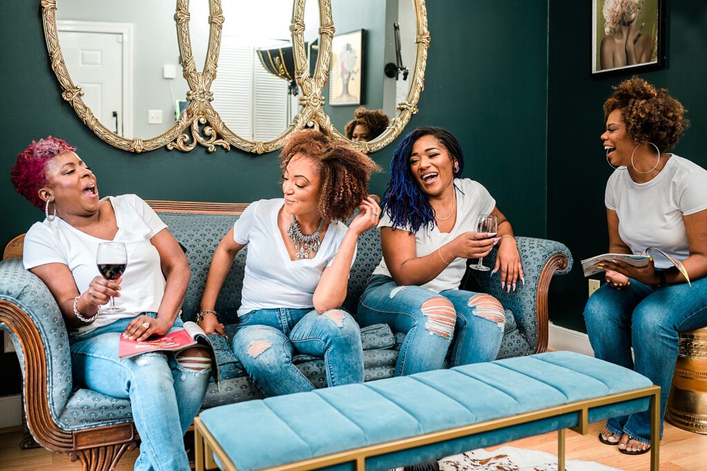 group of black women hanging out in living room, laughing and enjoying one another, Self-Care for Black Women Entrepreneurs
